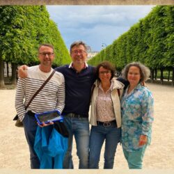 Groupe Famille dans le Jardin du Palais proche des Passages couverts à Paris avec une tablette digitale bleu dans les mains