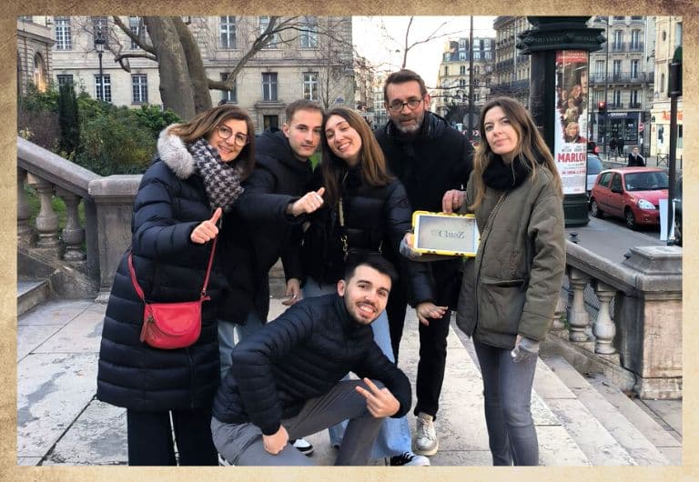 Groupe d'amis en extérieur, devant le collège de france avec une tablette digitale jaune