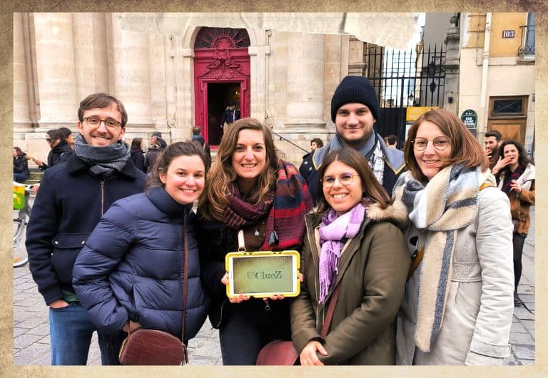 Groupe de détectives devant l'église Saint Paul dans le quartier du Marais à Paris avec une tablette digitale jaune