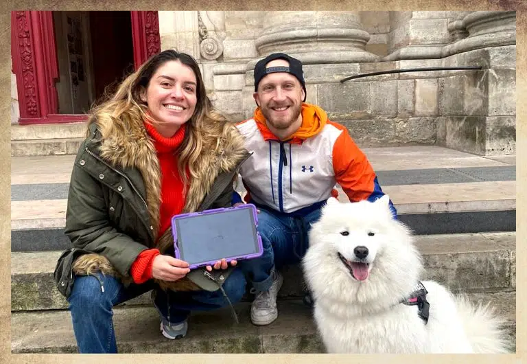 Couple d'amoureux devant l'église saint paul avec le chien et une tablette digitale violette