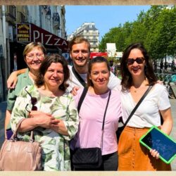 Groupe d'amis avec une tablette digitale verte devant l'Eglise Saint Paul dans le Marais à Paris