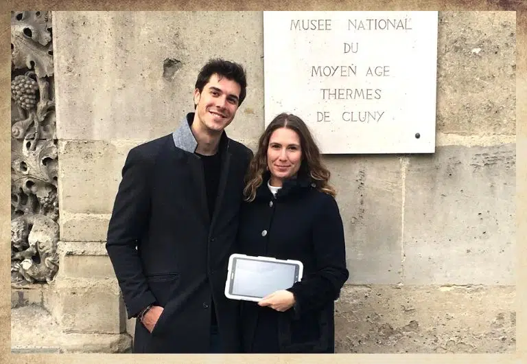 Duo couple devant le musée de cluny dans le quartier latin avec une tablette digitale blanche dans les mains
