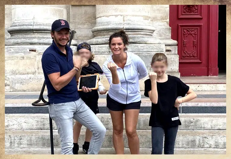 Groupe, portrait de famille avec les enfants durant un escape game dans le marais à Paris avec une tablette orange dans les mains