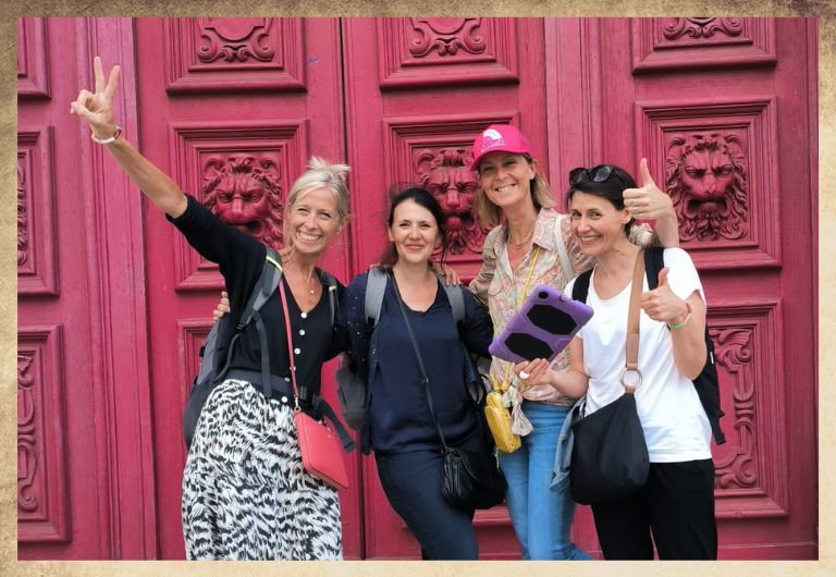 Groupe de filles devant l'église Saint Paul dans le Marais à Paris, avec une tablette digitale violette dans les mains pour jouer à ClueZ Paris